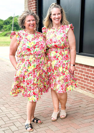 bright floral print smocked waist dress with pockets, ruffle sleeve and neck and one around the bottom  - print colors are yellow, pinks, reds and some green