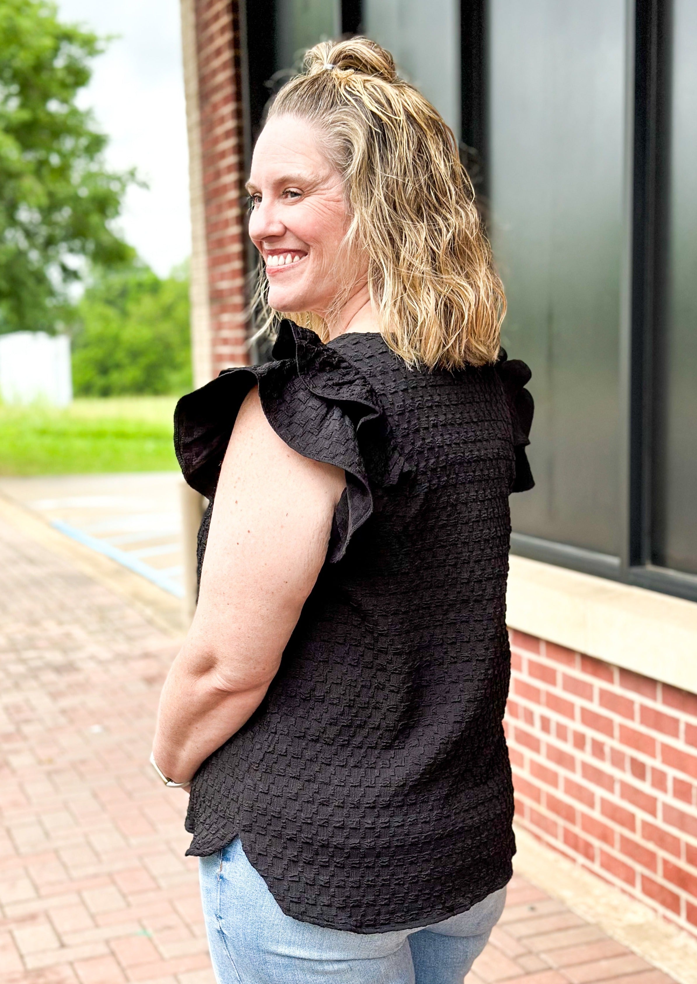 Black textured v-neck top with double ruffle sleeve