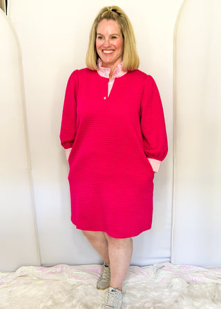Hot pink quilted dress with striped collar and three-quarter sleeves.