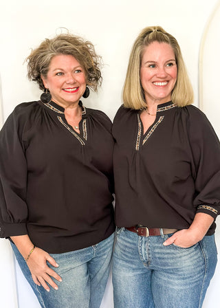 Textured black blouse with leopard lace detail on v-neckline and cuffs.
