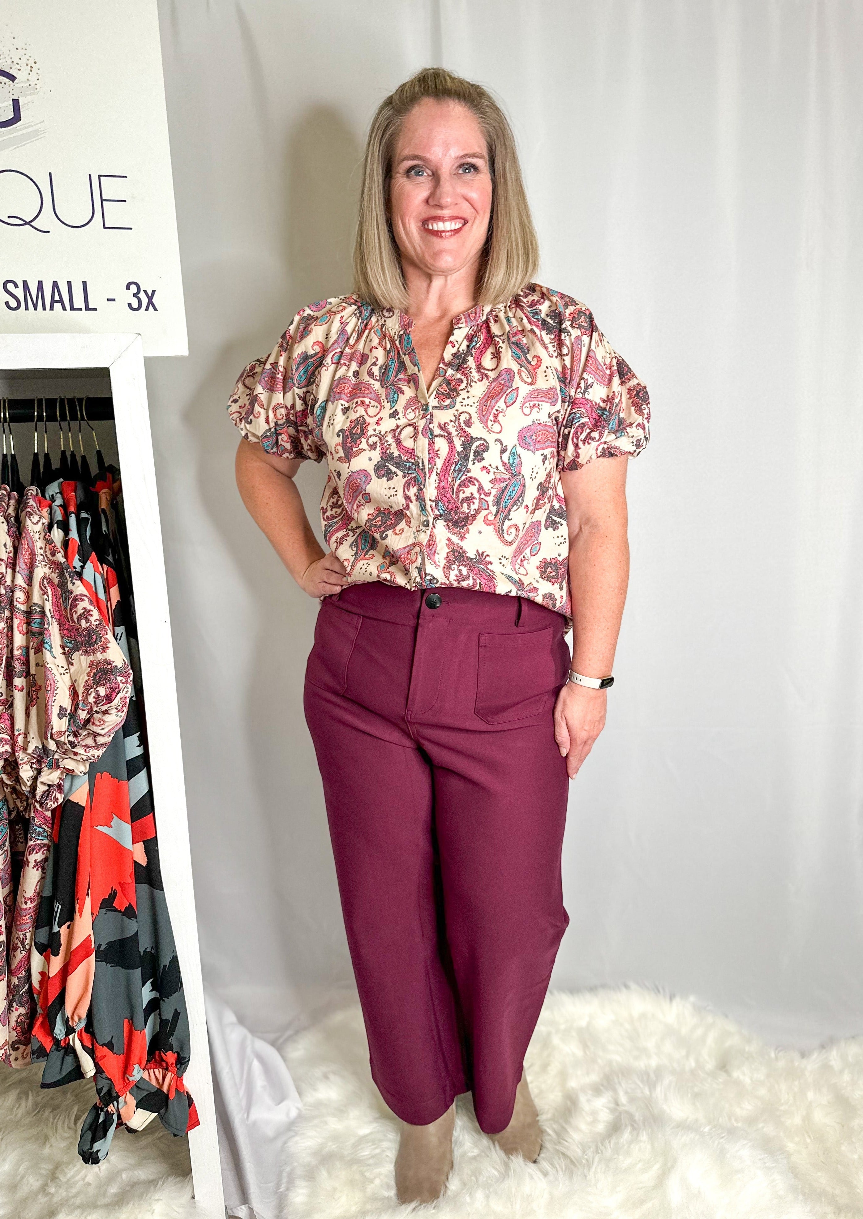 Front of the wine colored cropped pants showing 2 front square pockets, belt loops, and black button.