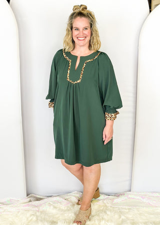 Knee length dark green dress with leopard detail around chest.  3/4 puff sleeve, split neckline, pockets.