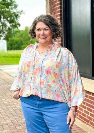 Pastel abstract print with building - v-neck with tie and ruffle - dolman 3/4 sleeve with elastic - lightweight