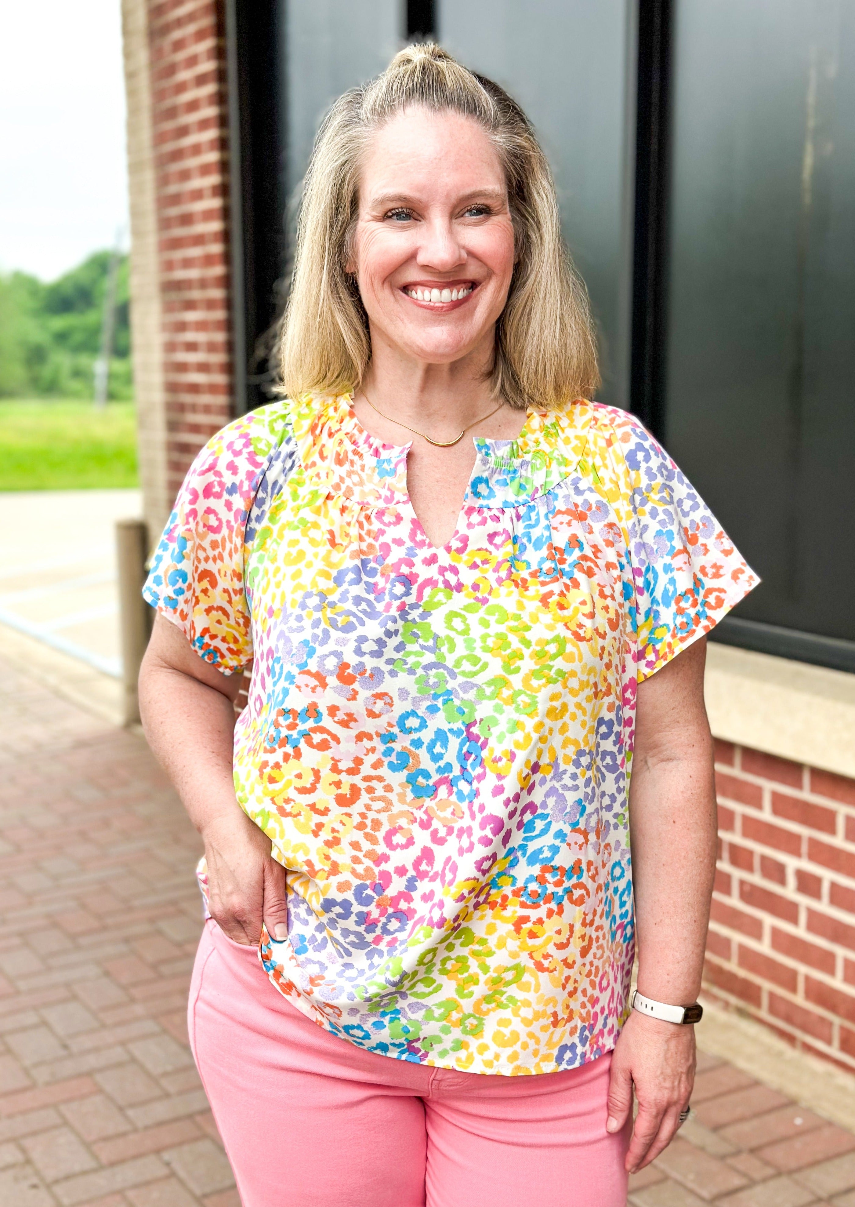 bright colored leopard print top - pinks, green, yellow, blue and orange leopard print on a white background - ruffle v-neck