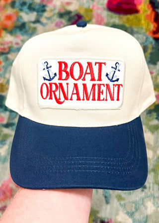 cream baseball hat with navy bill and boat ornament embroidered patch - snap back