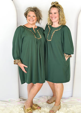 Knee length dark green dress with leopard detail around chest.  3/4 puff sleeve, split neckline, pockets.