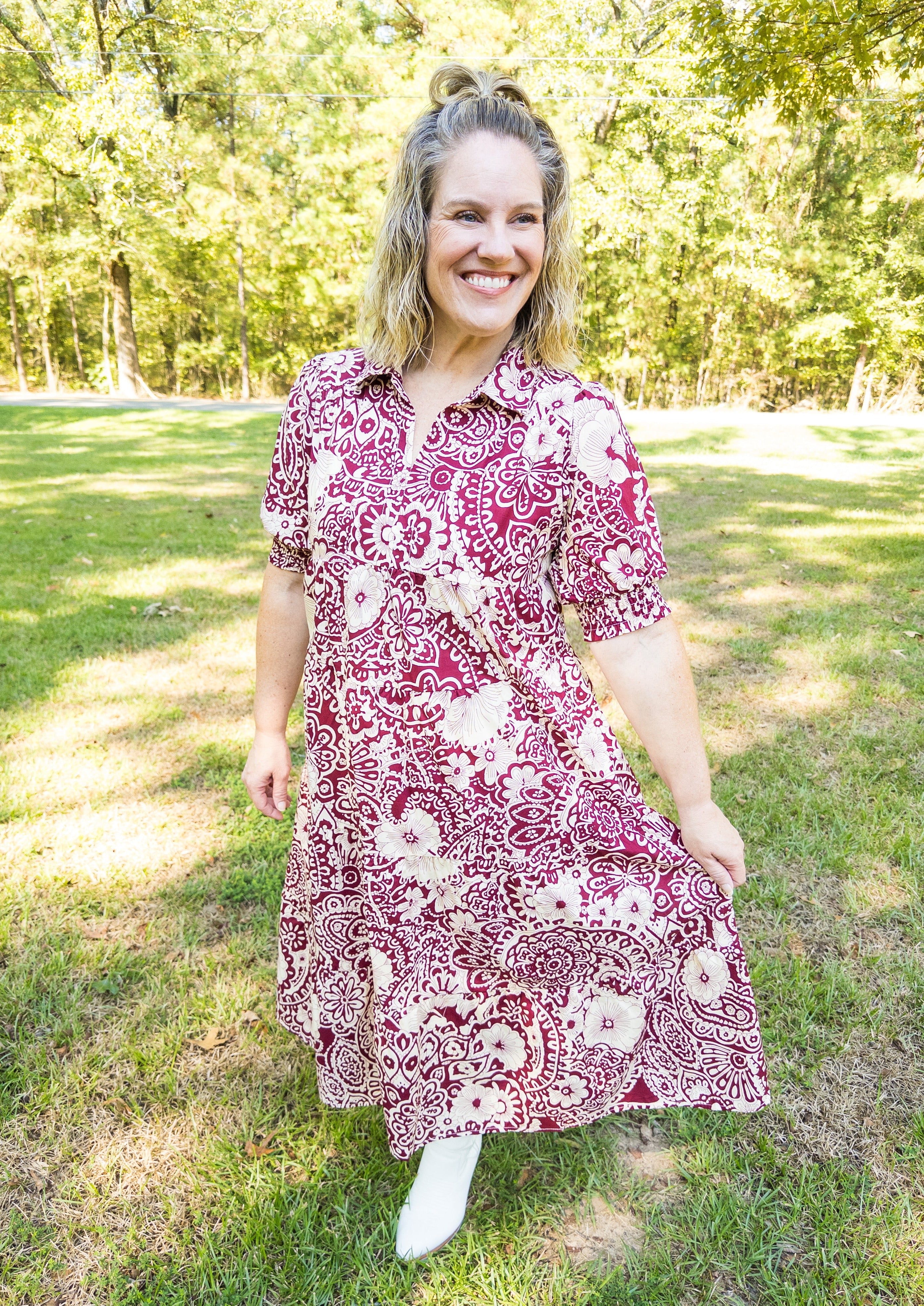 Off white abstract design with flowers on a sangria/wine colored background. Midi length, below the knee. V-neckline with collar. Little balloon sleeve with wide elastic banded cuff above elbow.