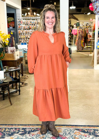 Long sleeve tiered midi dress with pockets, v-neck and ruffle around the neckline – color is pumpkin