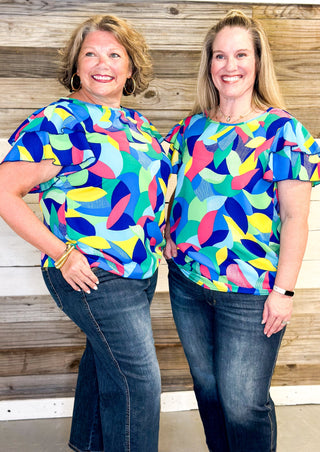 bright colors form a geometric pattern - no stretch recommended to size up - double ruffle sleeve - short sleeve top - colors of blues, pink, green, yellow