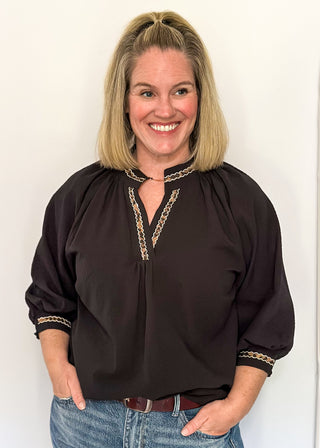 Textured black blouse with leopard lace detail on v-neckline and cuffs.