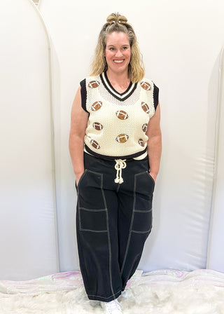 Black balloon style pants with rope drawstring waist. White stitching around pockets and crop cut.