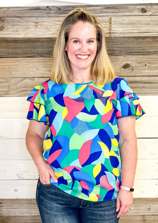 bright colors form a geometric pattern - no stretch recommended to size up - double ruffle sleeve - short sleeve top - colors of blues, pink, green, yellow