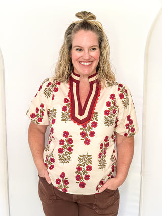 Woman wearing a floral blouse with a plain background
