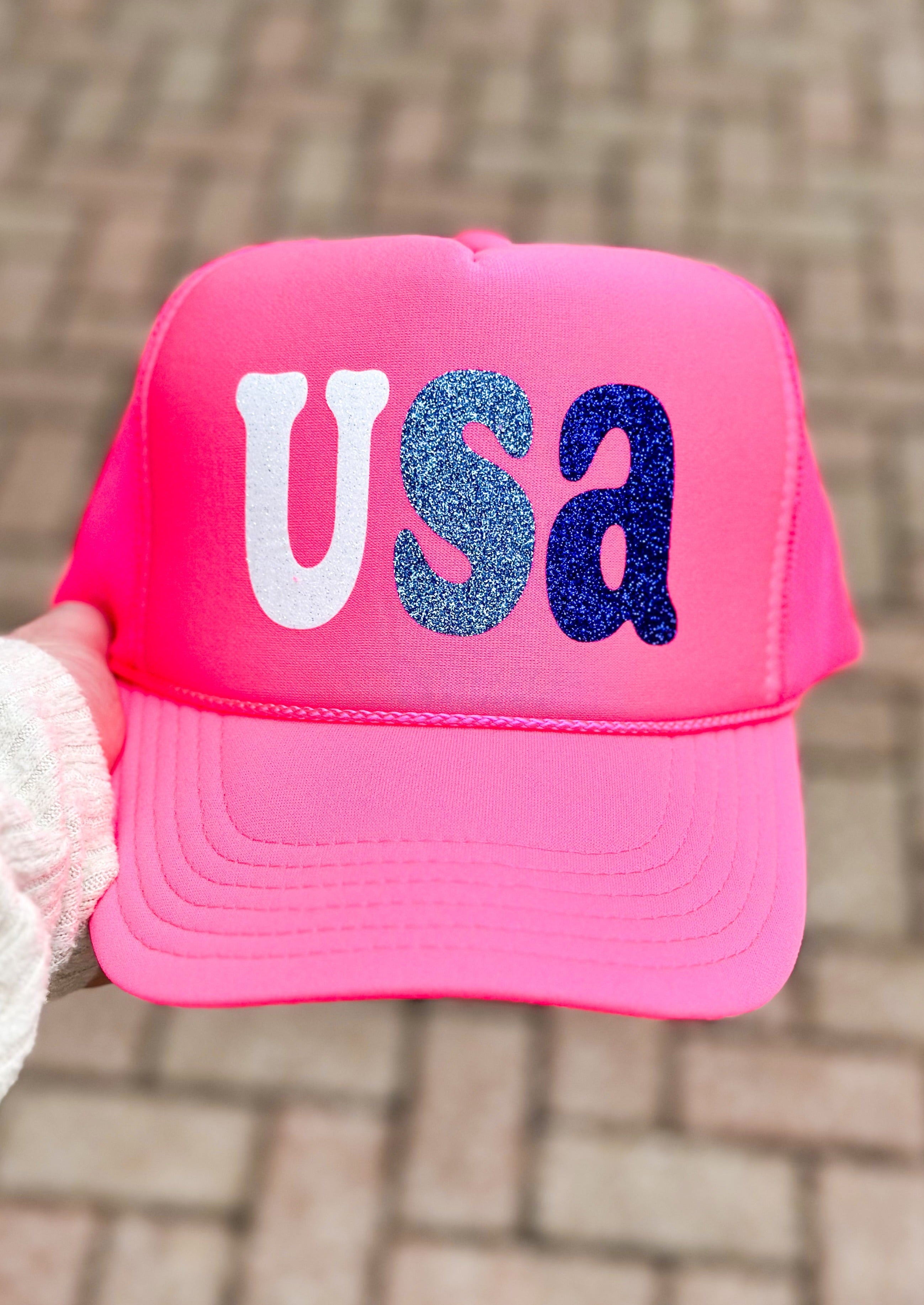 Pink trucker hat with USA across the front in glitter - white U, light blue S, blue a