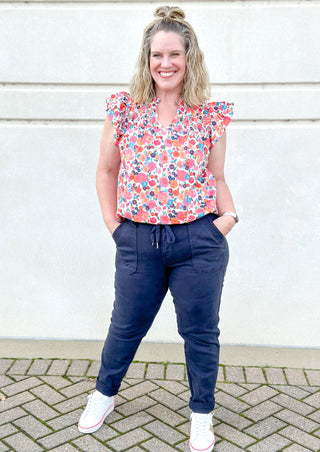 Navy blue denim joggers with cuffed hem that can be rolled or unrolled, button and zipper closure with drawstring, front and back pockets
