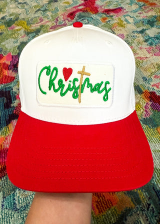 Red and white cap with 'Christmas' text on a colorful fabric background