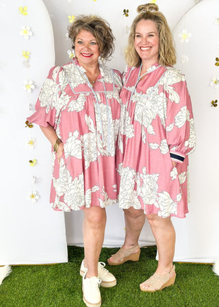 Pink Dress with large cream flowers.  Tie front collar with 3/4 oversized balloon sleeve- contrasting color stripe on the sleeve, lined with pockets.