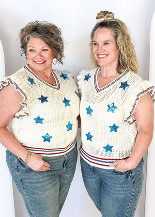 ruffle short sleeve net like cream sweater - need to wear something underneath - blue sequin star patches and red and blue trim around v-neck, bottom banding and ruffle on sleeve