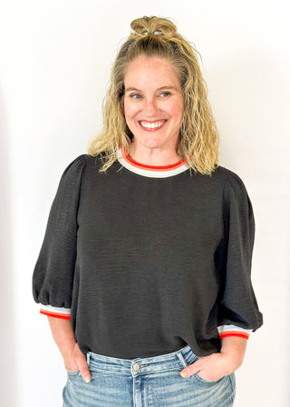 black loose fitting top with 3/4 length sleeve - round neck and cuff have colored banding
