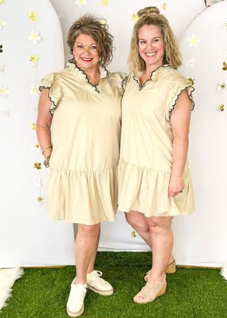 Short sleeve tiered ruffle dress with pockets. Double scallop detail in contrasting color on sleeves and  v-neck.