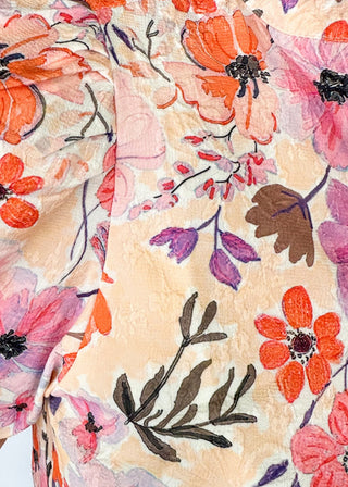 bright floral top with striped detail around arm band and v-neck - purples, peach, blush, pinks and white - short puff sleeve with little shoulder pads