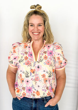 bright floral top with striped detail around arm band and v-neck - purples, peach, blush, pinks and white - short puff sleeve with little shoulder pads