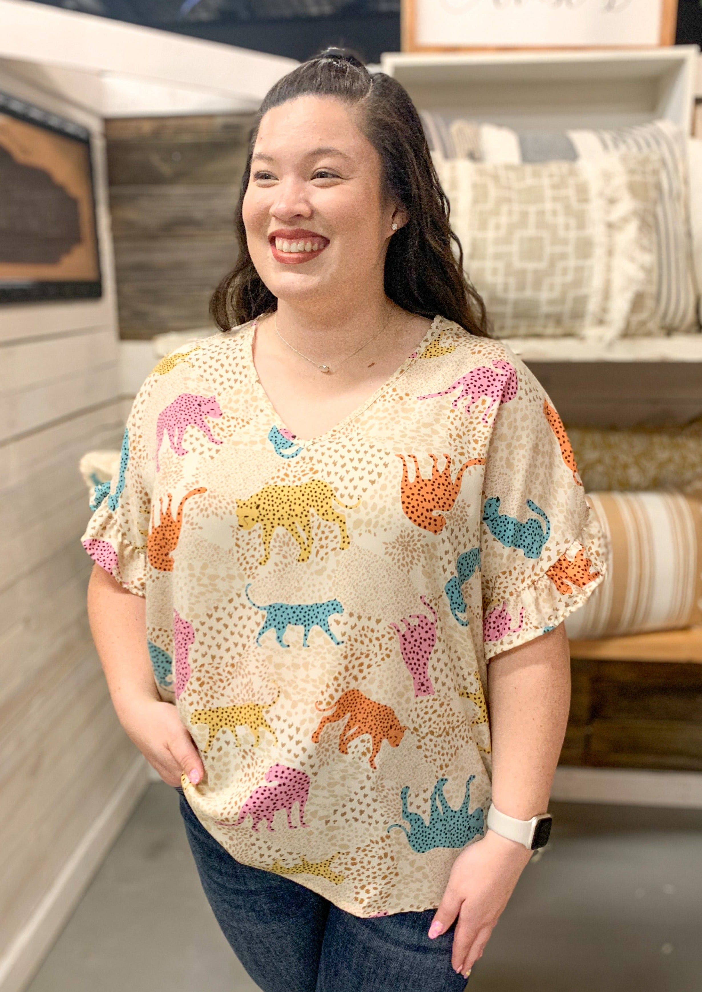 cream v neck top with ruffle sleeve. blue yellow orange and pink cheetahs