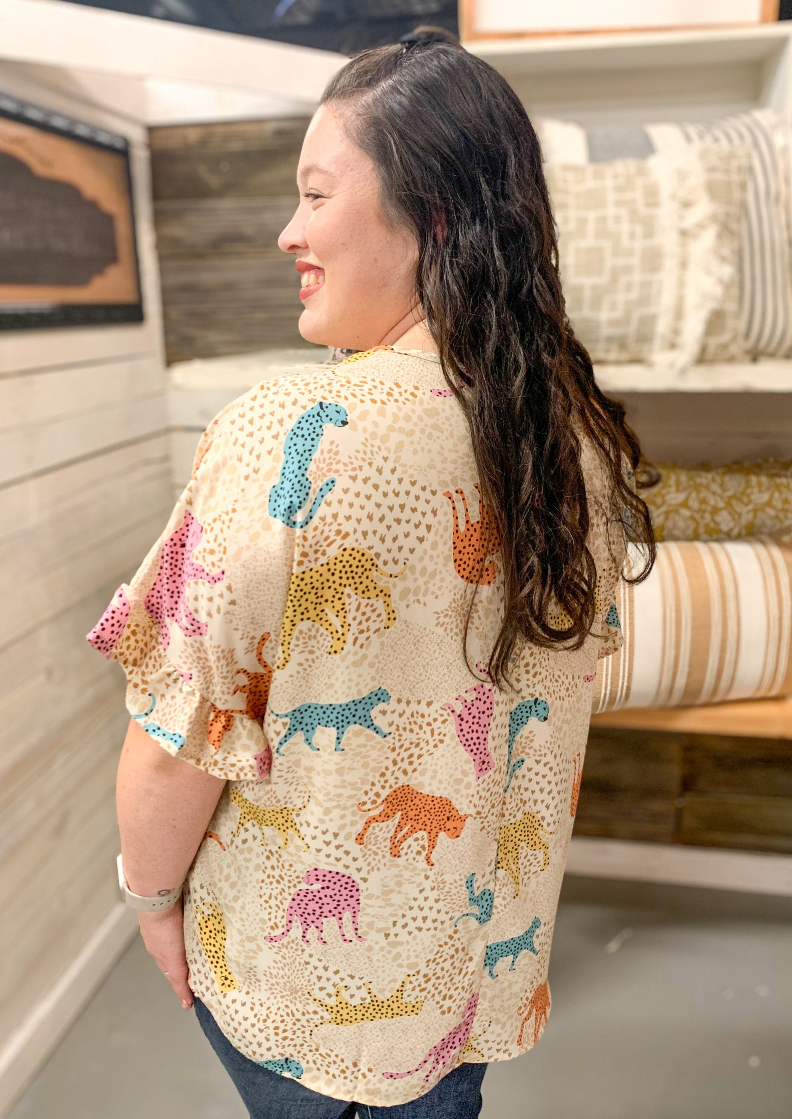 cream v neck top with ruffle sleeve. blue yellow orange and pink cheetahs