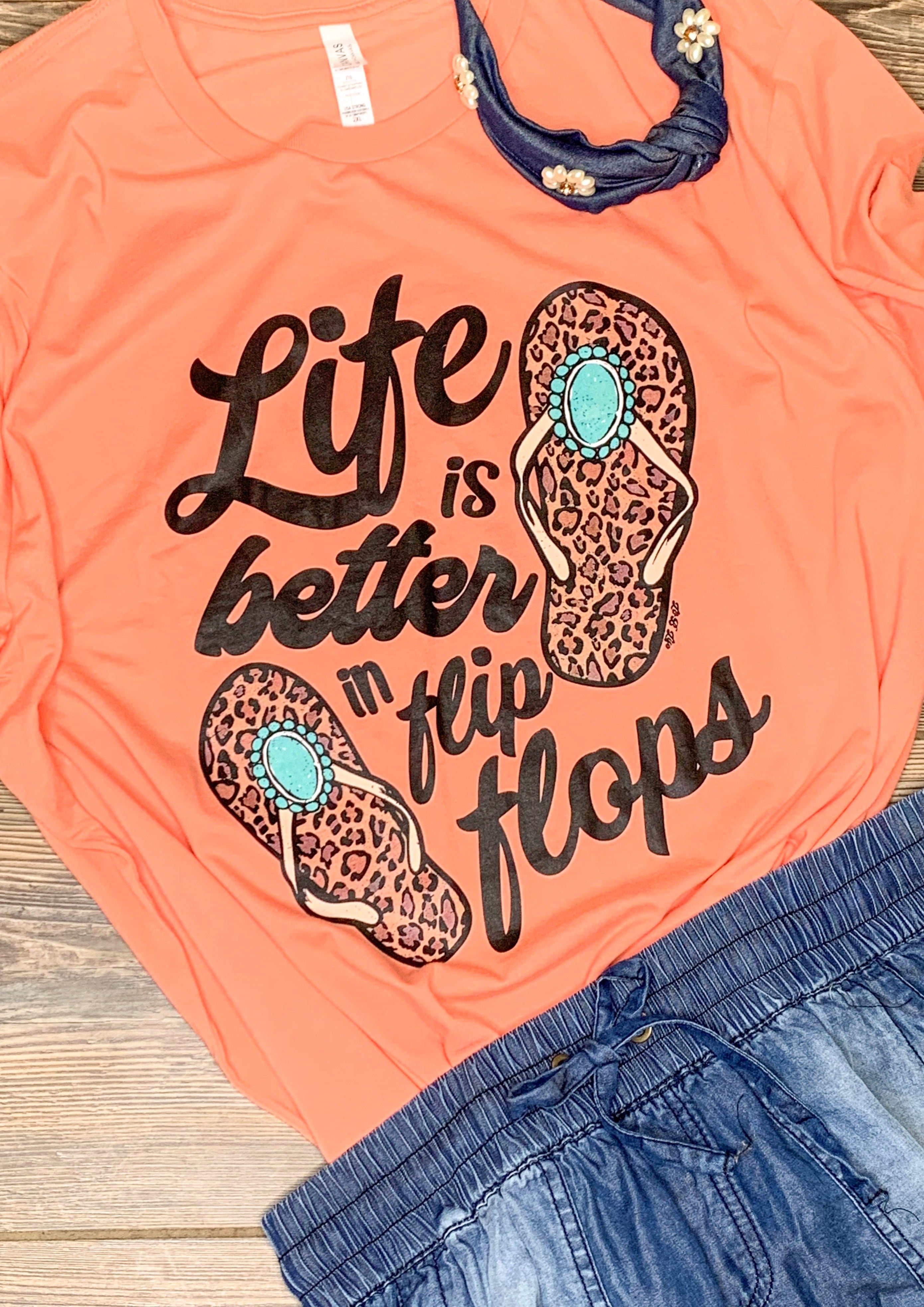 Coral colored tee with "life is better in flip flops" graphic.