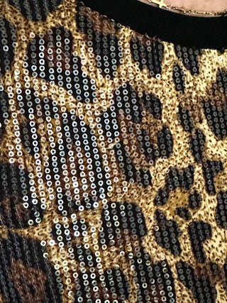 Animal print sequin shirt featuring short sleeves and black contrast trim on the neckline and sleeves.