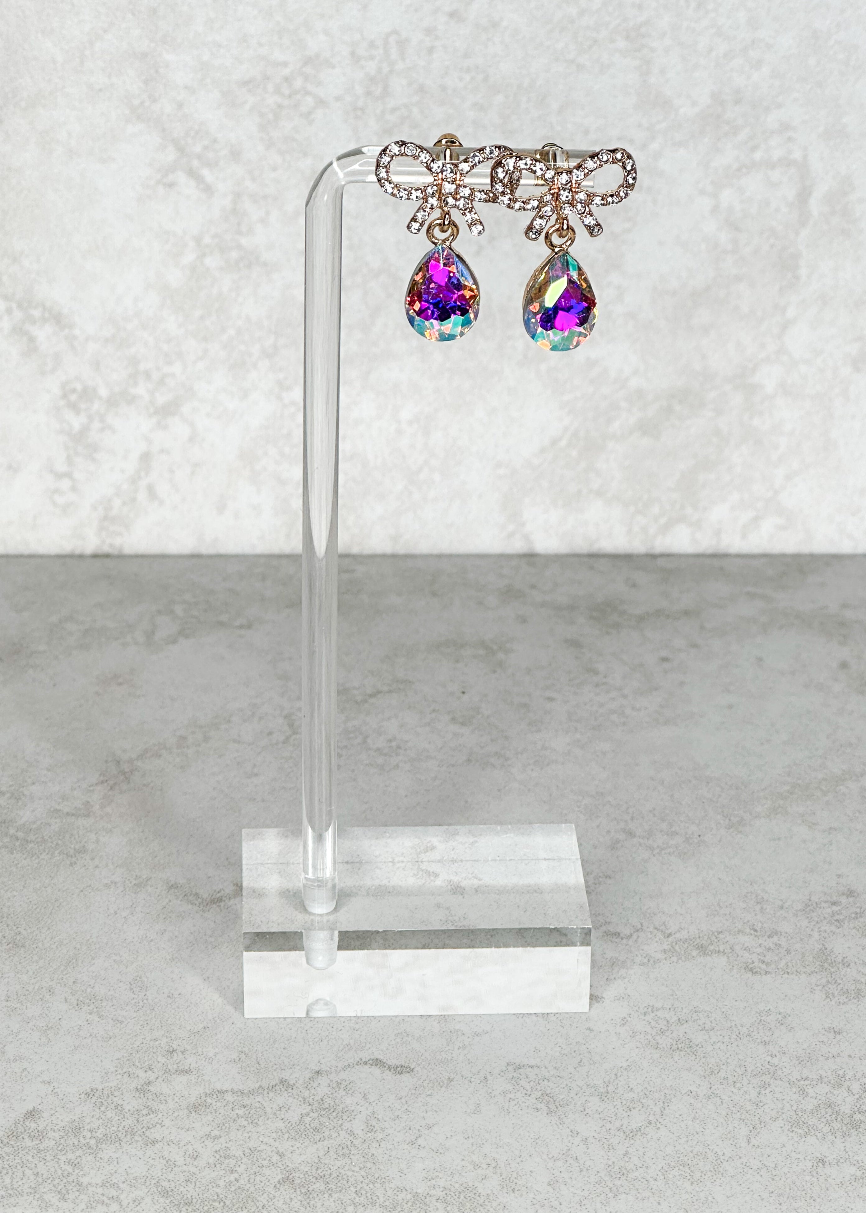 Sparkly bows with iridescent teardrops and gold hardware post back earrings.