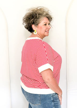 Woman wearing a red and white striped shirt with blue jeans against a white background
