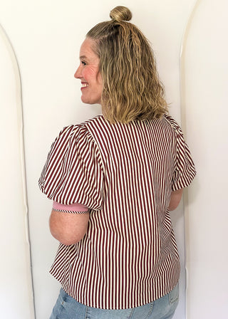 woman wearing burgundy stripe button up top.