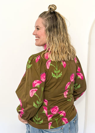 pink florals on brown long sleeve top with shades of pink ruffle around collar and down the front - button up