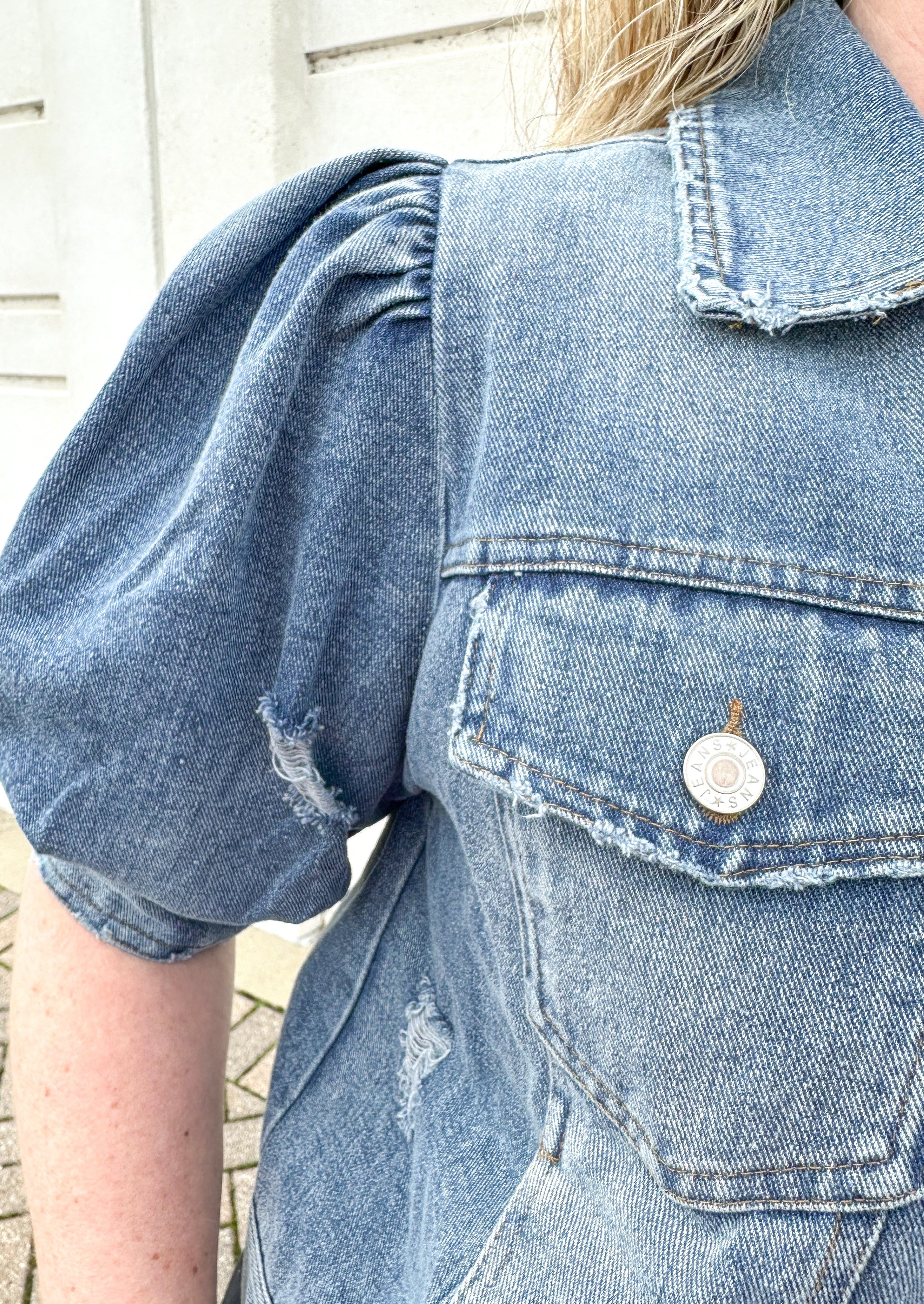Short puff sleeve jean jacket with banding on the arms,  silver buttons for front closure, collar, pockets on both sides