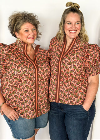 Bubble sleeve V-neck short sleeve top with terracotta, brown and green print. Ribbon detail down the front in brown and terracotta. 
