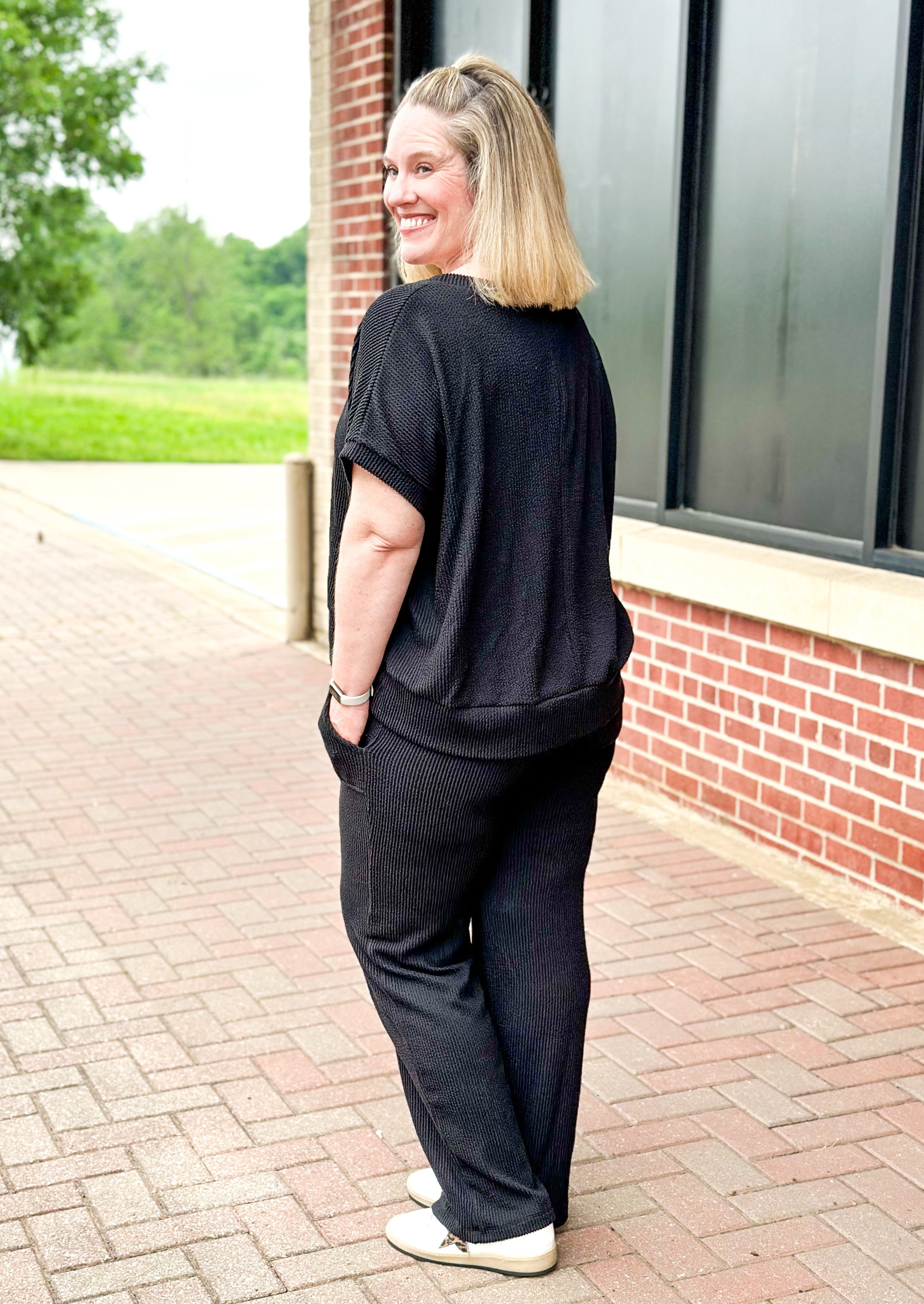 textured black set top and pants - pants have pockets and banded waist - top has a drop shoulder dolman sleeve with banding around the bottom.