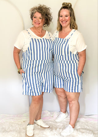 Blue and white striped shorts romper with front pocket and back pockets with heart cut out. 