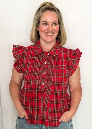 woman wearing red plaid shirt with flutter sleeves and rhinestone buttons.