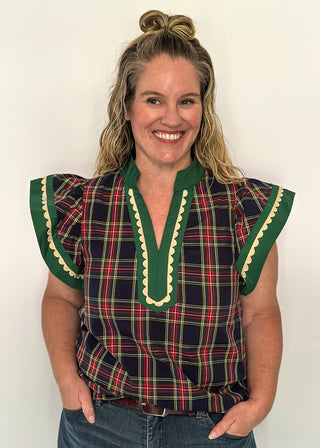 Navy plaid flutter sleeve top with green contrast neckline and scallop trim detail