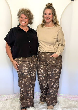 brown wide leg pants with belt loops, zipper and button closure, front and back pockets, creamy floral pattern throughout