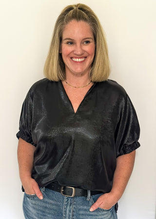 Shimmer black V-neck blouse with relaxed elastic short sleeves and a split hem at waist. 