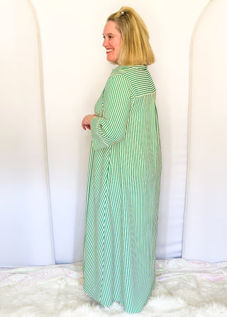 Green vertical striped collared dress with button-down front with green contrast, 3/4 sleeves, midi length, and side pockets.