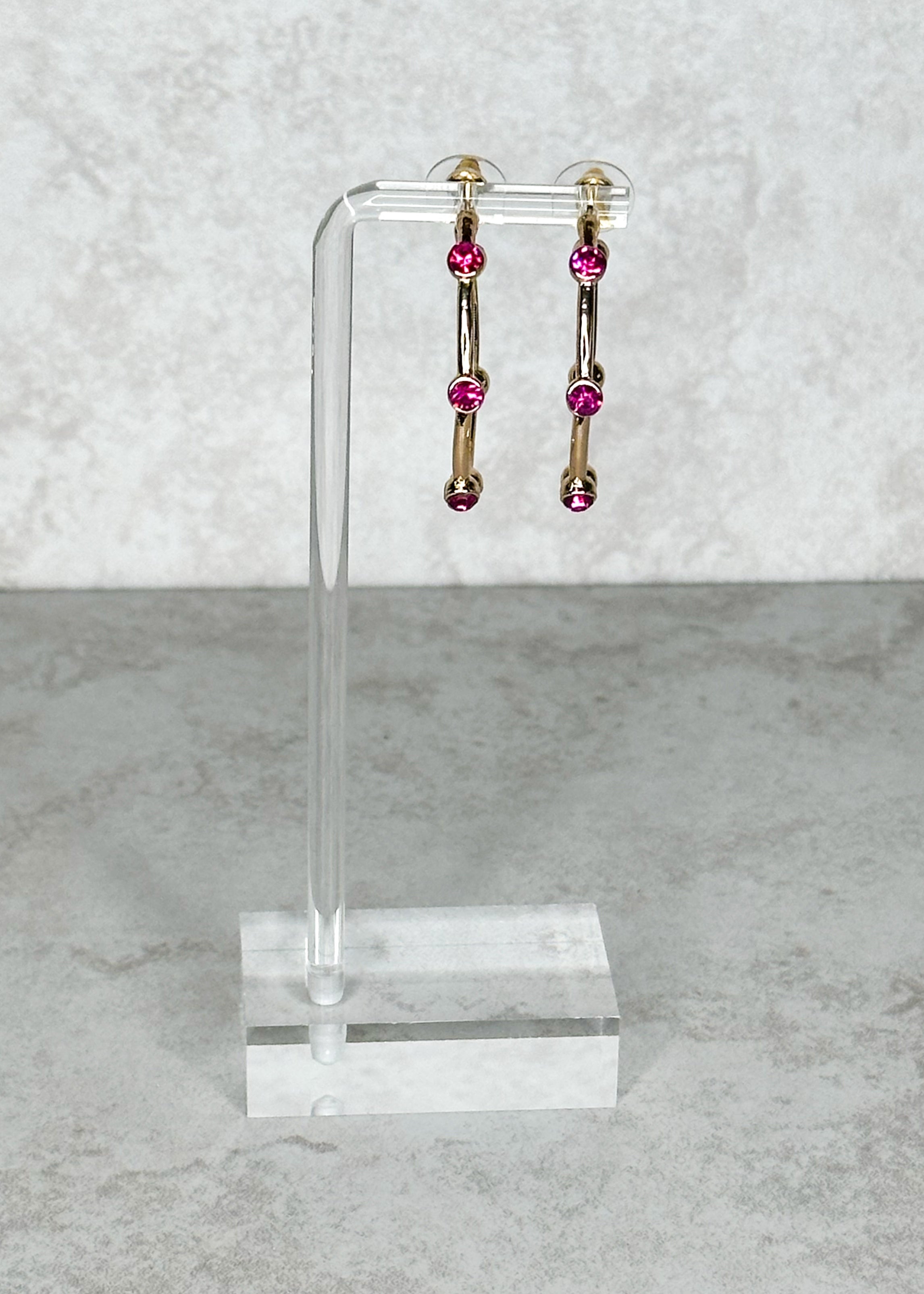 Gold with magenta colored jewels, open hoop, post back earrings.