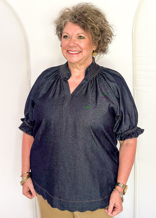 Women's indigo denim-look blouse featuring a smocked split neckline, puff sleeves, and a relaxed fit.