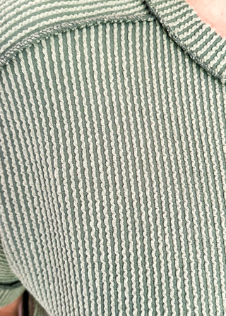 Close-up of a textured green fabric with a subtle pattern
