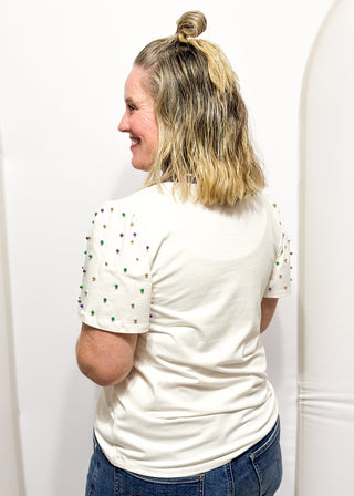 Short sleeve top with pearl accents with sequin "Mardi Gras" wording.
