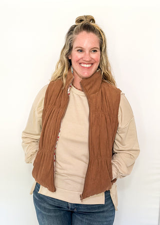 Reversible puffer vest with red and pink floral on one side, brown corduroy on the other.  Pockets on both sides, collared with zipper closure.