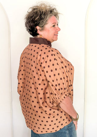 woman in camel dolman top with chocolate polka dots.