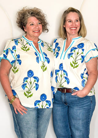 white top with oversized blue flower pattern and short sleeves